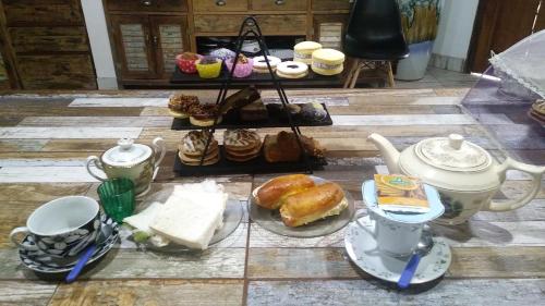 a table with a bunch of pastries and cups and tea at La Casa del Árbol in Carmen de Areco