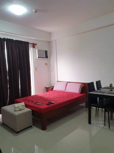 een slaapkamer met een rood bed en een piano bij HI RESIDENCES in Bacolod