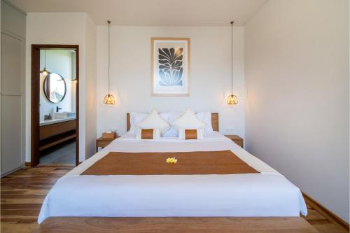 um quarto com uma grande cama branca e uma casa de banho em Green Villa Canggu em Canggu