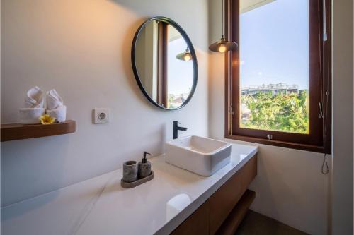 uma casa de banho com um lavatório e um espelho em Green Villa Canggu em Canggu