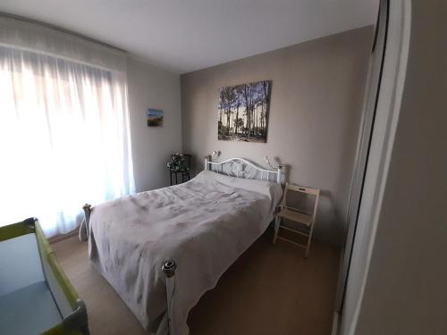 een slaapkamer met een bed met een witte sprei en een raam bij Appartement Arcachon, 3 pièces, 6 personnes - FR-1-319-449 in Arcachon