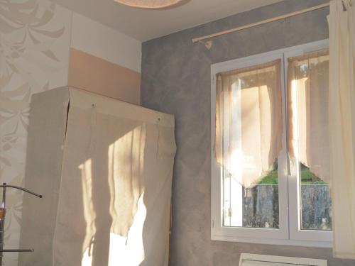 une cuisine avec une fenêtre et un rideau dans l'établissement Maison proche forêt, plage et commerces - 2 ch, terrasse, jardin clos, parking privé, animaux acceptés - FR-1-22-231, à La Tranche-sur-Mer