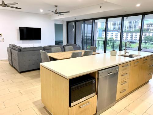 an open kitchen and living room with a couch at Serenity Splendour at Darwin Waterfront in Darwin
