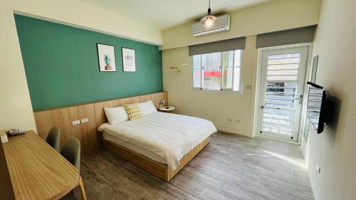 a small bedroom with a bed and a table at 古栗Chestnut Guest House-可包棟民宿 in Taitung City