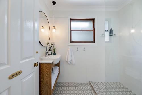 een witte badkamer met een wastafel en een douche bij Maleny Town Stay in Maleny