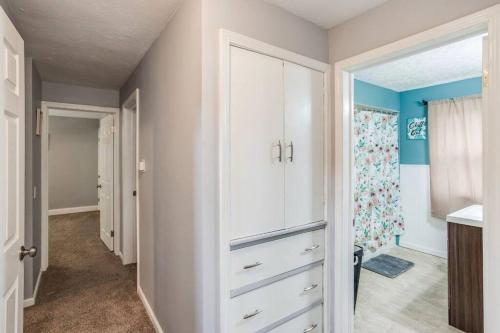 a kitchen with white cabinets and blue walls at Astonishing Home Mins Away Airport/Dwtn/UofR/RIT in Rochester