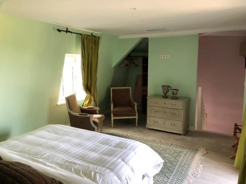 um quarto com uma cama, 2 cadeiras e uma cómoda em Cottage Jardin Duplex of 70 m² for 2 people – 1 bedroom – 2 bathrooms – em Azay-le-Rideau