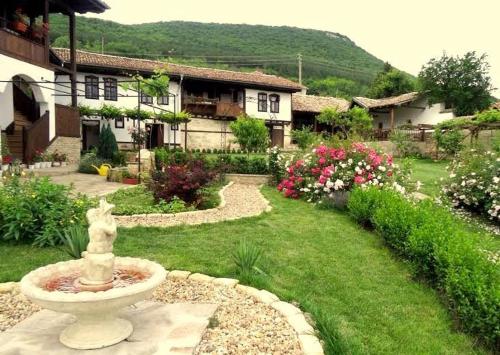 a garden with a fountain in front of a house at Osmarski Houses in Osmar