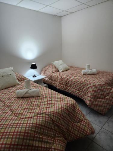 dos camas sentadas una al lado de la otra en una habitación en Tu Espacio en Río Grande