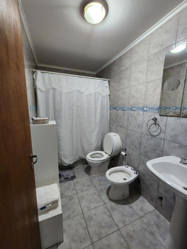 a bathroom with a toilet and a sink at Tu Espacio in Río Grande