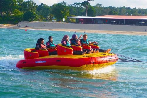 a group of people riding on a raft in the water at Lotus Desaru Beach Resort, 2 bdrms, w/splash park in Bandar Penawar