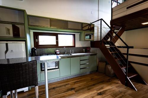 una cucina con armadi verdi e una scala a chiocciola di Chalé Casal - Sítio Vale Encantado a Treviso