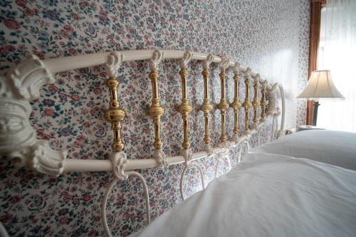 a bedroom with a bed and floral wallpaper at Albergo Allegria Hotel & Breakfast Restaurant in Windham
