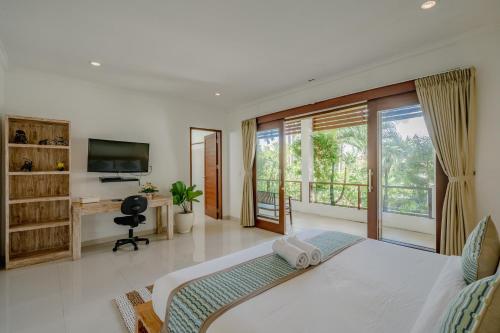 Dormitorio con cama, escritorio y TV en Villa Alleira Seminyak by Best Deals Asia Hospitality, en Seminyak