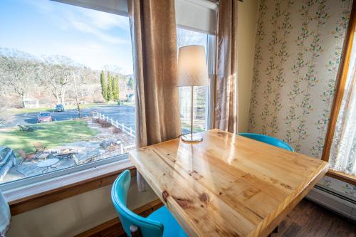 a wooden table and chairs in a room with a window at Albergo Allegria Hotel & Breakfast Restaurant in Windham