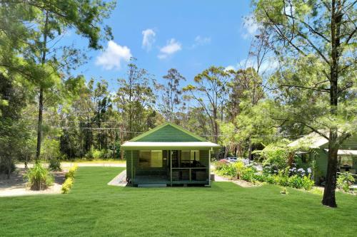 a gazebo with a green roof in a yard at Craigies Cabin in Kangaroo Valley