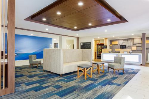an office lobby with a reception desk and chairs at Holiday Inn Express & Suites Newport News by IHG in Newport News