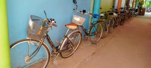 a row of bikes parked next to a wall at Rueangsrisiri Guesthouse 2 in Sukhothai