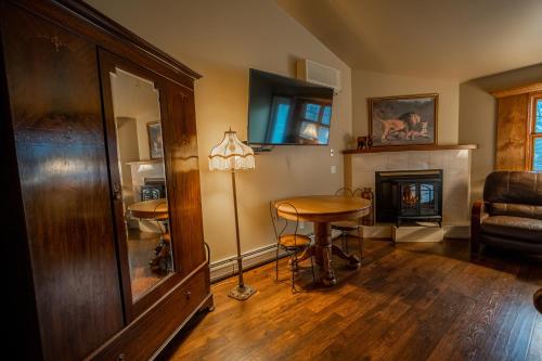 a living room with a table and a fireplace at Albergo Allegria Hotel & Breakfast Restaurant in Windham