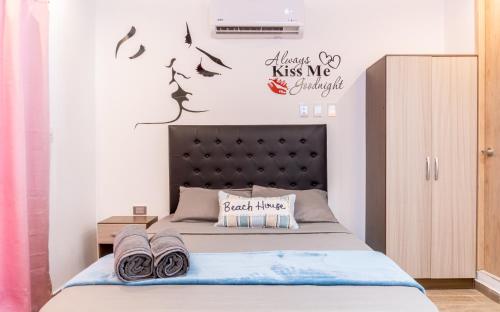 1 dormitorio con 1 cama con cabecero negro en Confort+Relax= Romántico ApartaEstudio + Piscina + Parqueadero, en Santa Marta