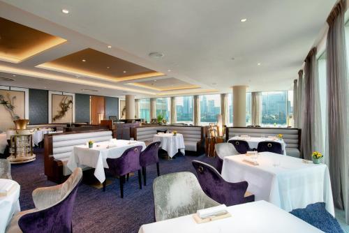 a restaurant with tables and chairs and windows at InterContinental London - The O2 in London