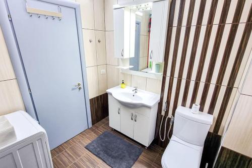 La salle de bains est pourvue de toilettes blanches et d'un lavabo. dans l'établissement City Center 2BR Apartment, à Tirana