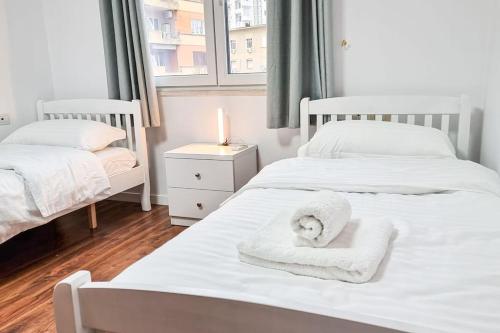 two beds with towels on them in a bedroom at City Center 2BR Apartment in Tirana