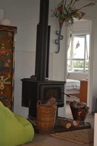 a living room with a black stove in a room at AHIPARA GOLDENSANDs in Ahipara