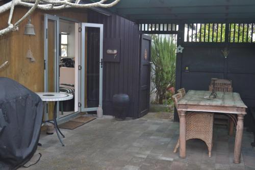 a patio with a table and a door to a house at AHIPARA GOLDENSANDs in Ahipara