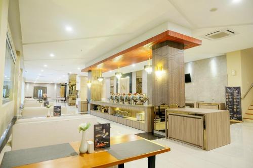 SidanegaraにあるAzana Asia Hotel Cilacapのカウンターとテーブル付きの広いキッチンが備わります。