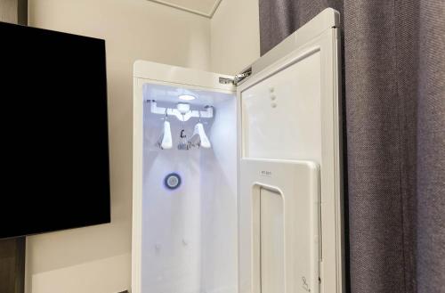 a white refrigerator with a tv in a room at Wonju Central Hotel in Wonju