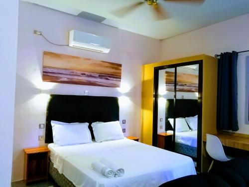 1 dormitorio con cama blanca y espejo en Marino Bungalows, en Bantayan Island