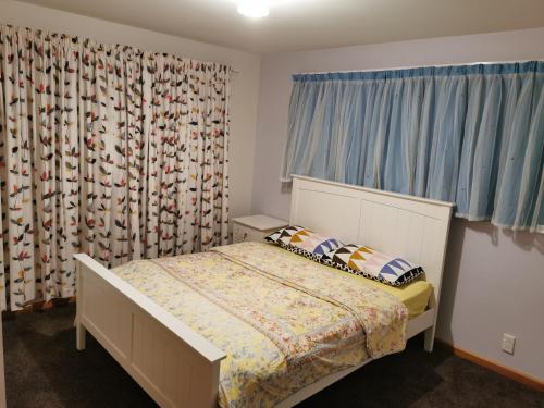 a bedroom with a bed and a window at Airport accommodation in Christchurch