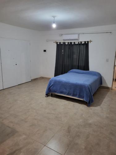 1 dormitorio con 1 cama con manta azul en Hostal Nazarena Herrera en Salta