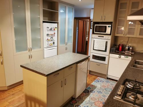 a kitchen with white appliances and granite counter tops at Airport accommodation in Christchurch
