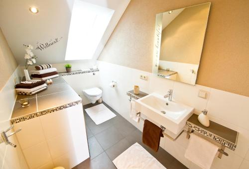 Baño blanco con lavabo y espejo en Komfort-Ferienwohnungen Horster, en Bensheim