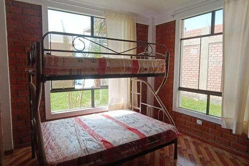 Etagenbett in einem Zimmer mit 2 Fenstern in der Unterkunft La casa de Alex in Piura