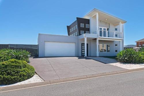 a large white house with a garage at On Seascape in Sellicks Beach