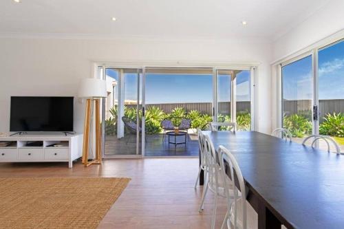 a living room with a large table and a television at On Seascape in Sellicks Beach
