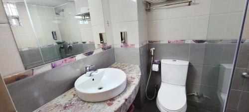 a bathroom with a sink and a toilet and a mirror at Hotel Afford Inn in Dhaka