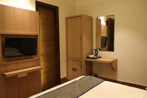 Pokój hotelowy z łóżkiem i lustrem w obiekcie Hotel Crown Savoy, Near Railway Station & GURU NANAK DEV UNIVERSITY w mieście Amritsar