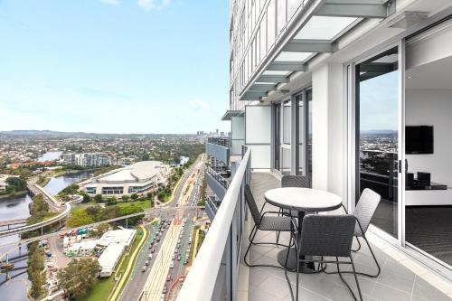 a balcony with a table and chairs overlooking a city at Meriton Suites Broadbeach in Gold Coast