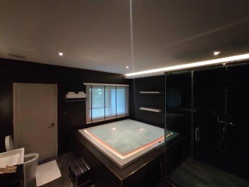 ein großes Bad mit einer Badewanne und einer Dusche in der Unterkunft Karnyapha Hotspring hotel in Ban Lum Than