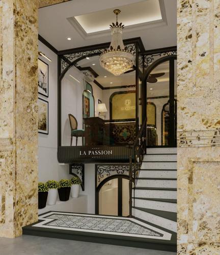 a staircase in a house with a chandelier at La Passion Hanoi Hotel & Spa in Hanoi
