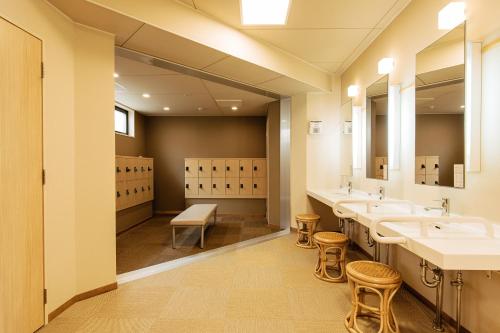a bathroom with three sinks and a row of mirrors at KAMENOI HOTEL Chitamihama in Mihama