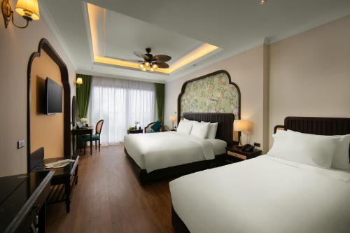 a hotel room with two beds and a television at La Passion Hanoi Hotel & Spa in Hanoi