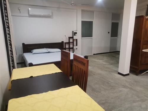 Una habitación con dos camas y dos mesas en ella. en Ceylon Ramble Villa, en Hikkaduwa