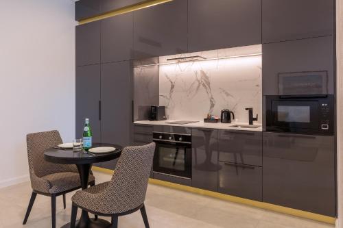 a kitchen with a table and chairs and a microwave at Meriton Suites Broadbeach in Gold Coast