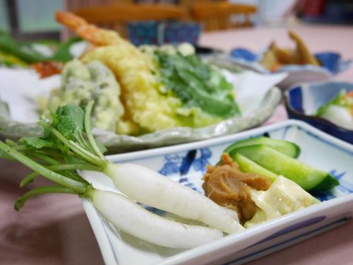 a tray of food with vegetables on a table at 池の平温泉 ロッジ コクハ in Myoko