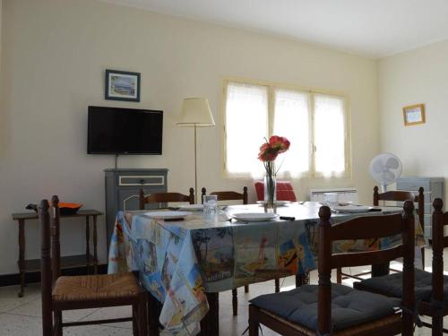 - un salon avec une table, des chaises et une télévision dans l'établissement Villa 5 pièces avec annexe, proche plage et commerces, terrasse et parking, SAINT PIERRE LA MER - FR-1-229D-209, à Saint Pierre La Mer